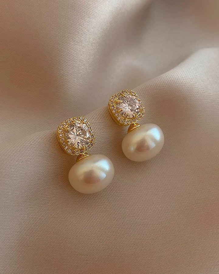 Brincos elegantes de tom off-white com brilho sutil