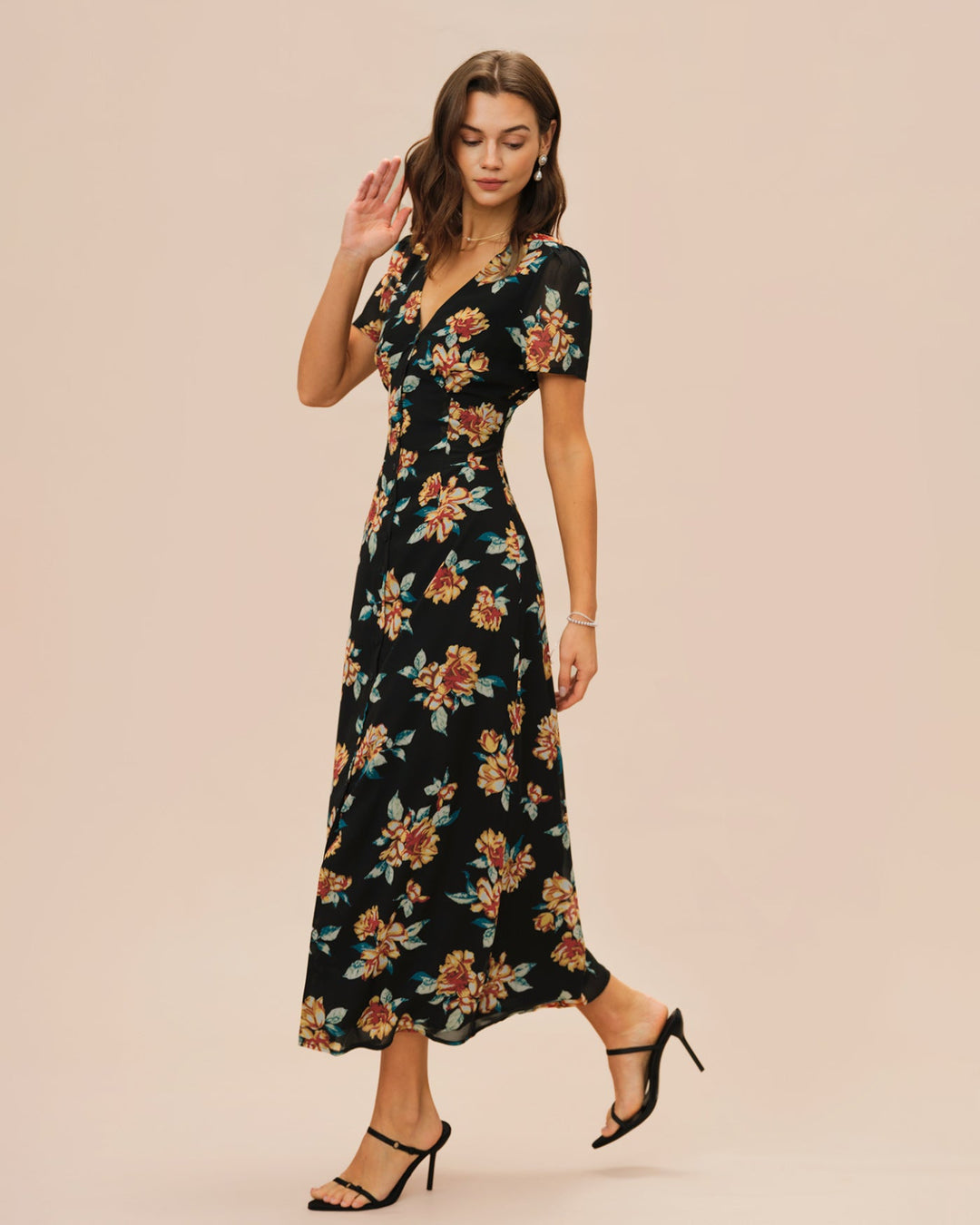 Vestido longo preto com estampa floral, decote em V e detalhe de botões frontais.