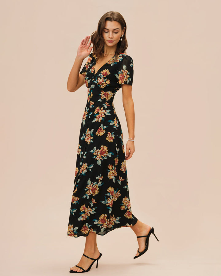Vestido longo preto com estampa floral, decote em V e detalhe de botões frontais.